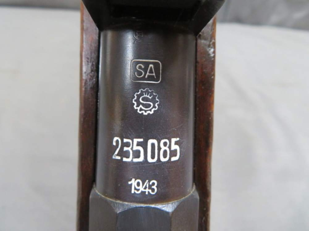 Close-up of the SAKO M/28-30 receiver ring showing the SA property mark, SAKO gear-wheel logo, serial number, and 1943 date stamp