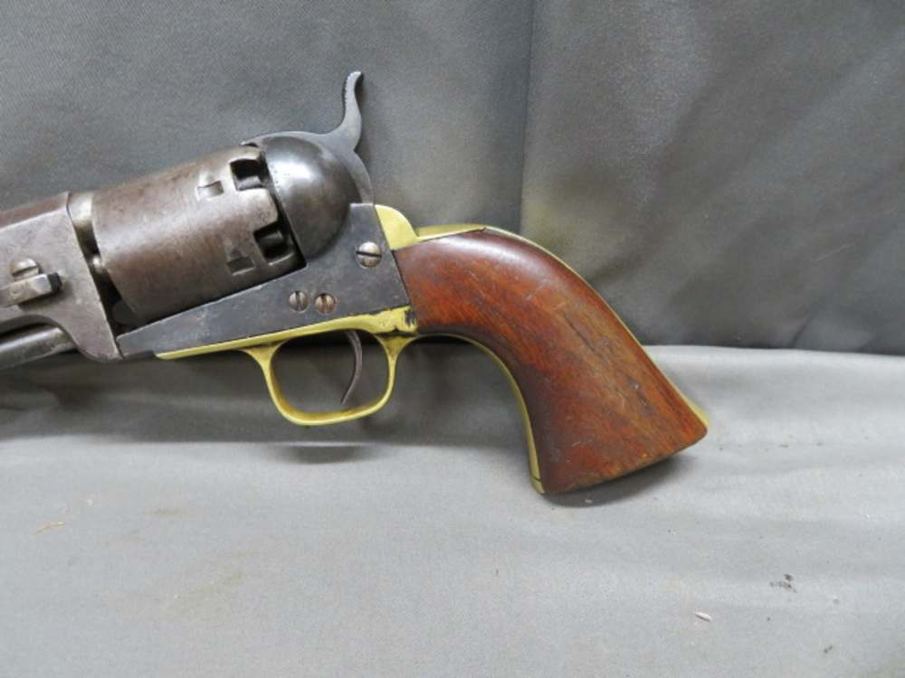 Close-up of the brass frame, cylinder, and walnut grip