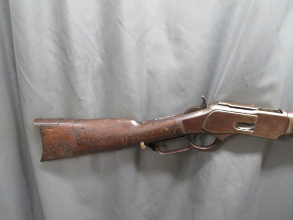 Antique Winchester Model 1873 lever-action rifle, close-up of receiver, hammer, lever, and trigger guard