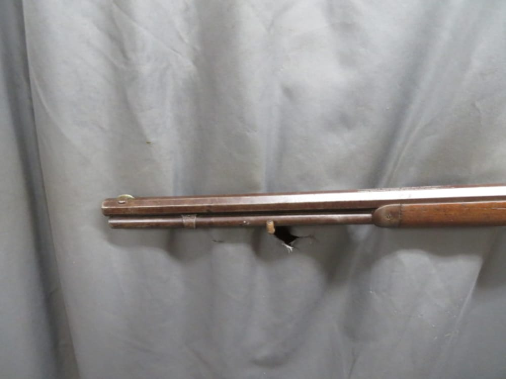 Antique Winchester Model 1873 lever-action rifle, close-up of muzzle, tube magazine, and forend