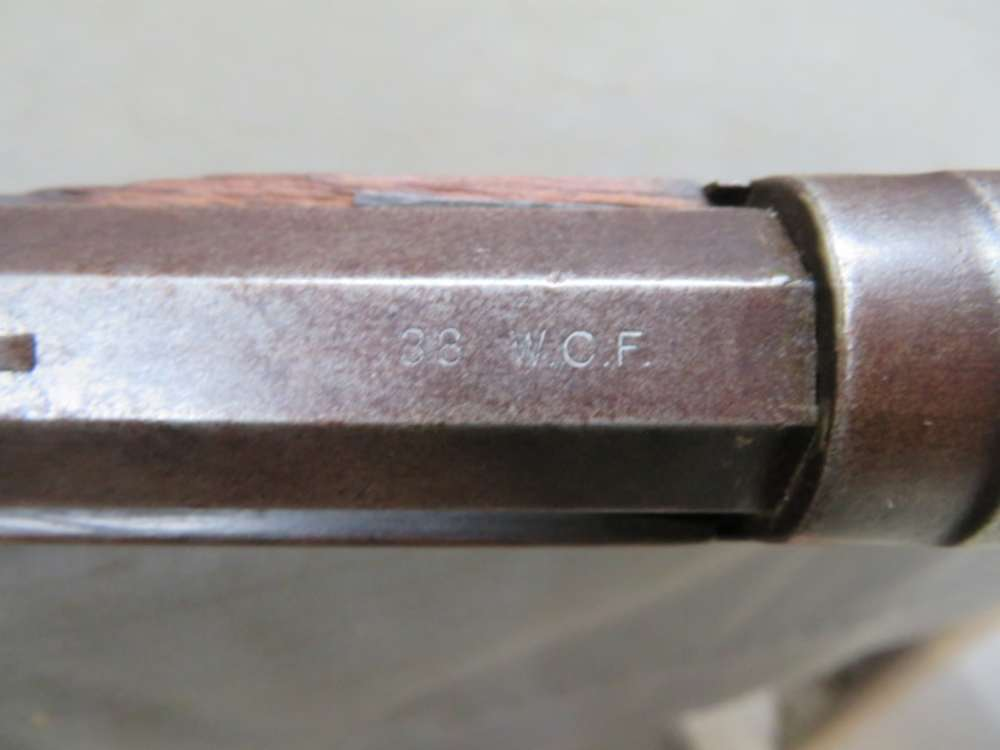 Antique Winchester Model 1873 lever-action rifle, close-up of .38 W.C.F. caliber stamp on barrel