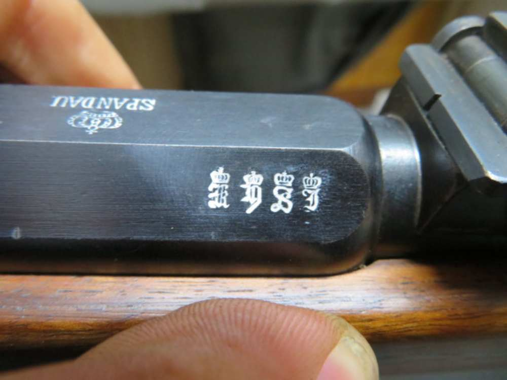 Close-up of the SPANDAU arsenal marking and imperial proof stamps on the receiver