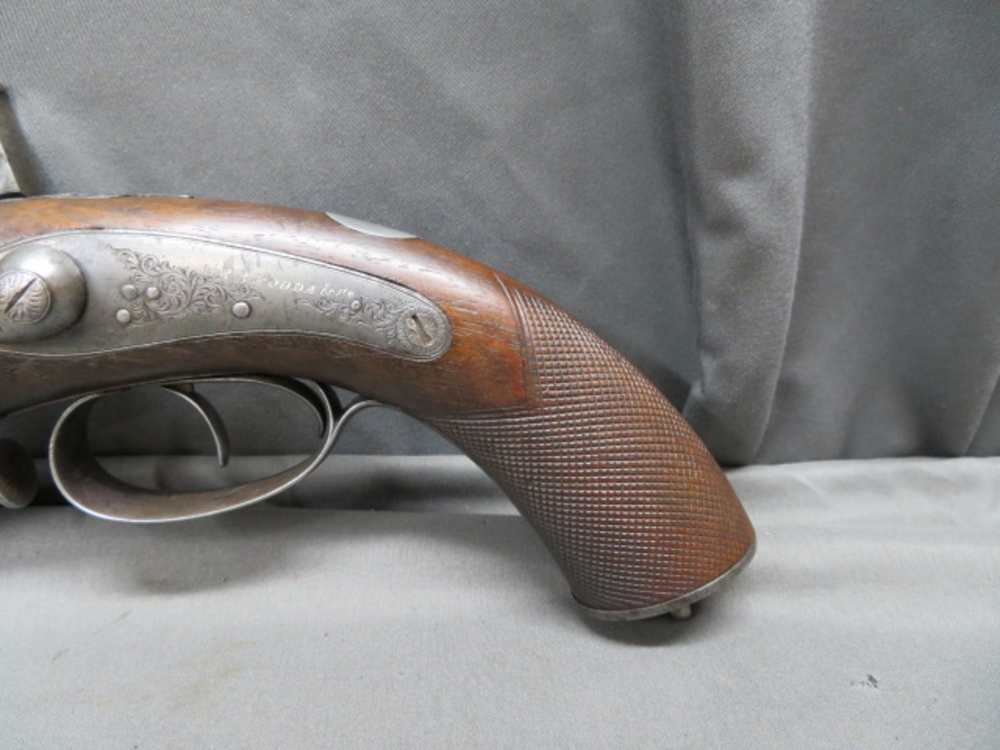 Close-up of the engraved lock plate and checkered grip on the Rodda howdah pistol