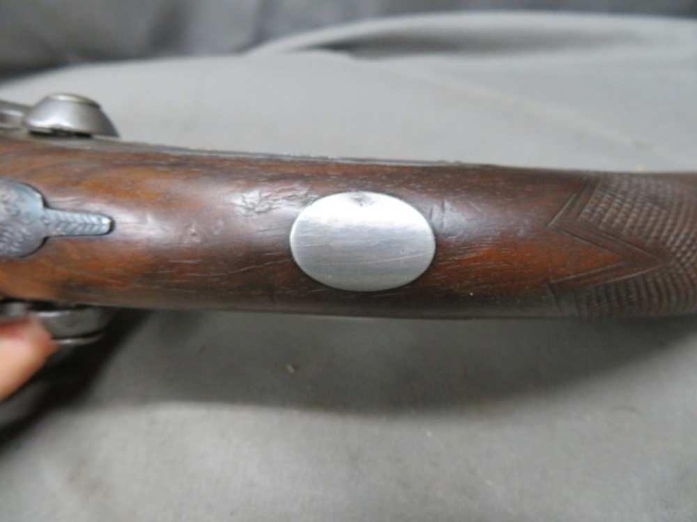 Close-up of an oval inlay on the grip strap of the Rodda howdah pistol